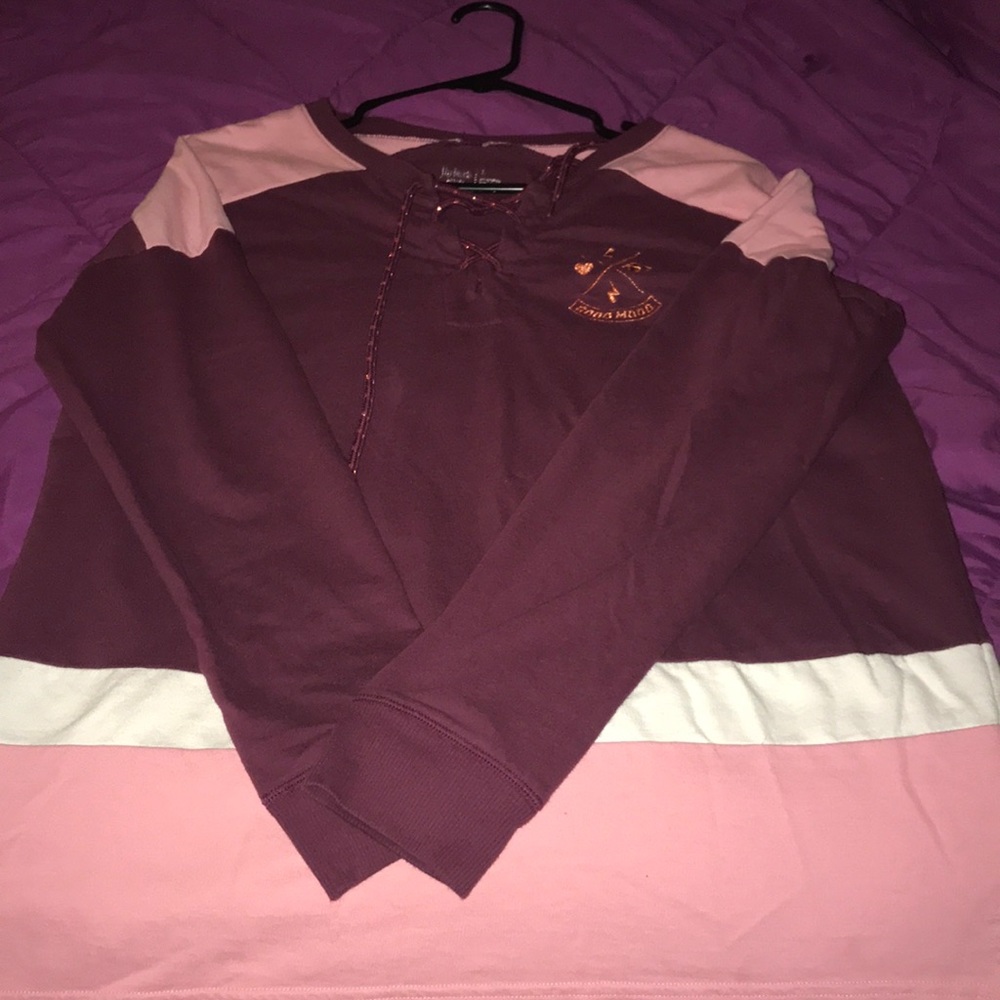 A burgundy shirt with pink and white on it